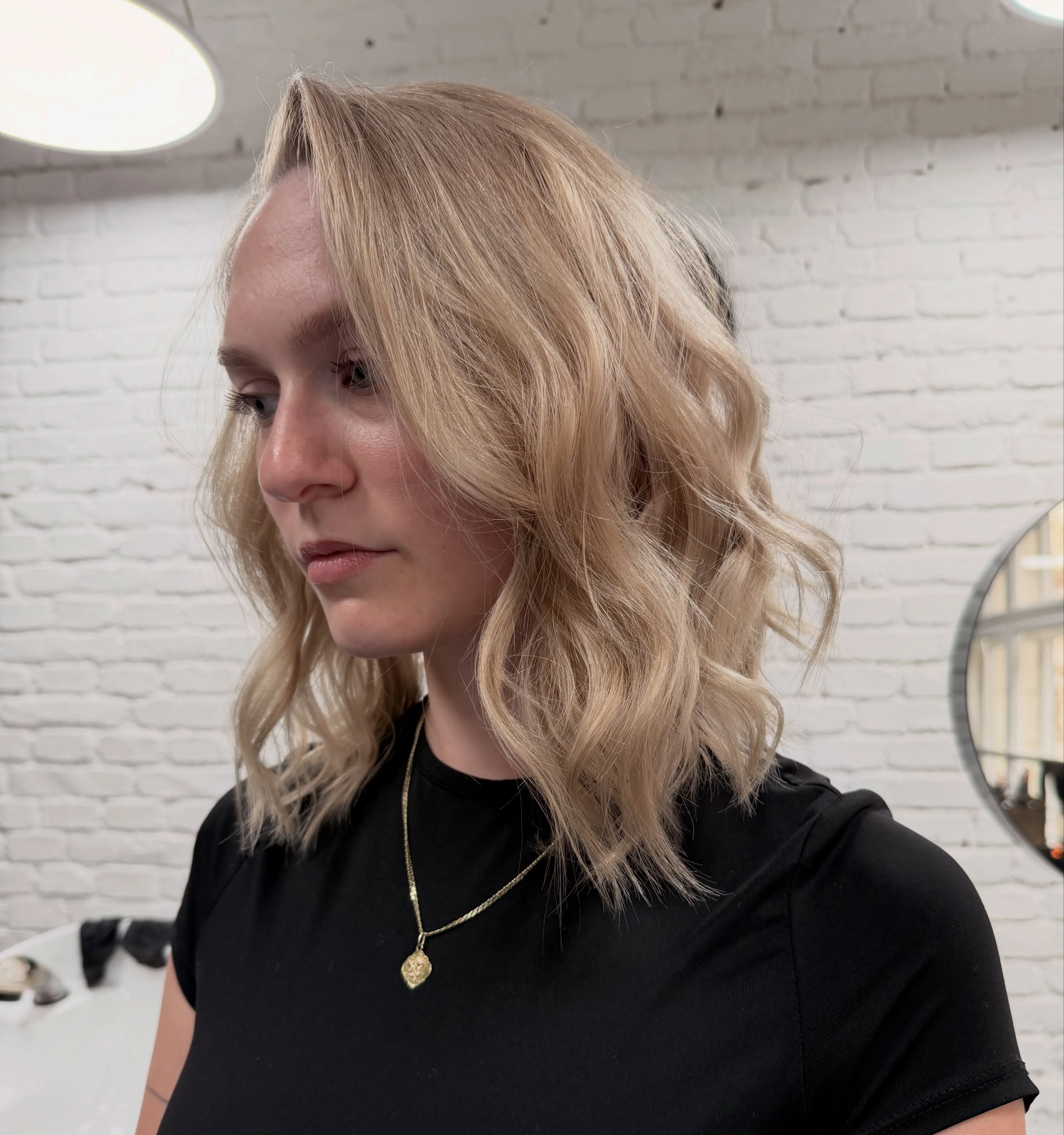 Světlá blond vlnitá mikáda po ramena, pohled z profilu