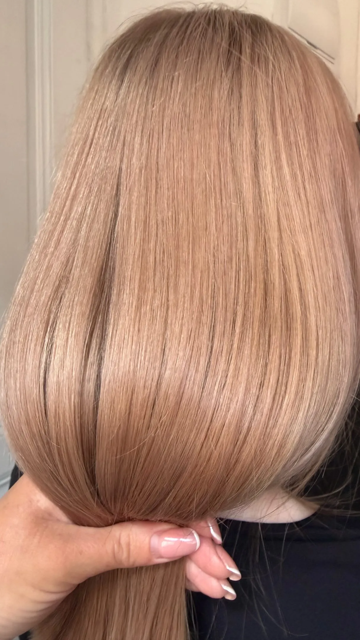 Detail světle blond dlouhých rovných vlasů stažených do nízkého culíku